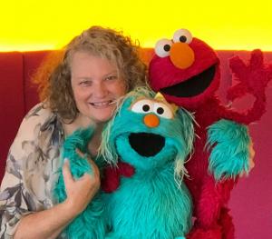 Tasha Weinstein poses with Sesame Street characters